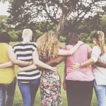 Diverse group of women with arms around each other